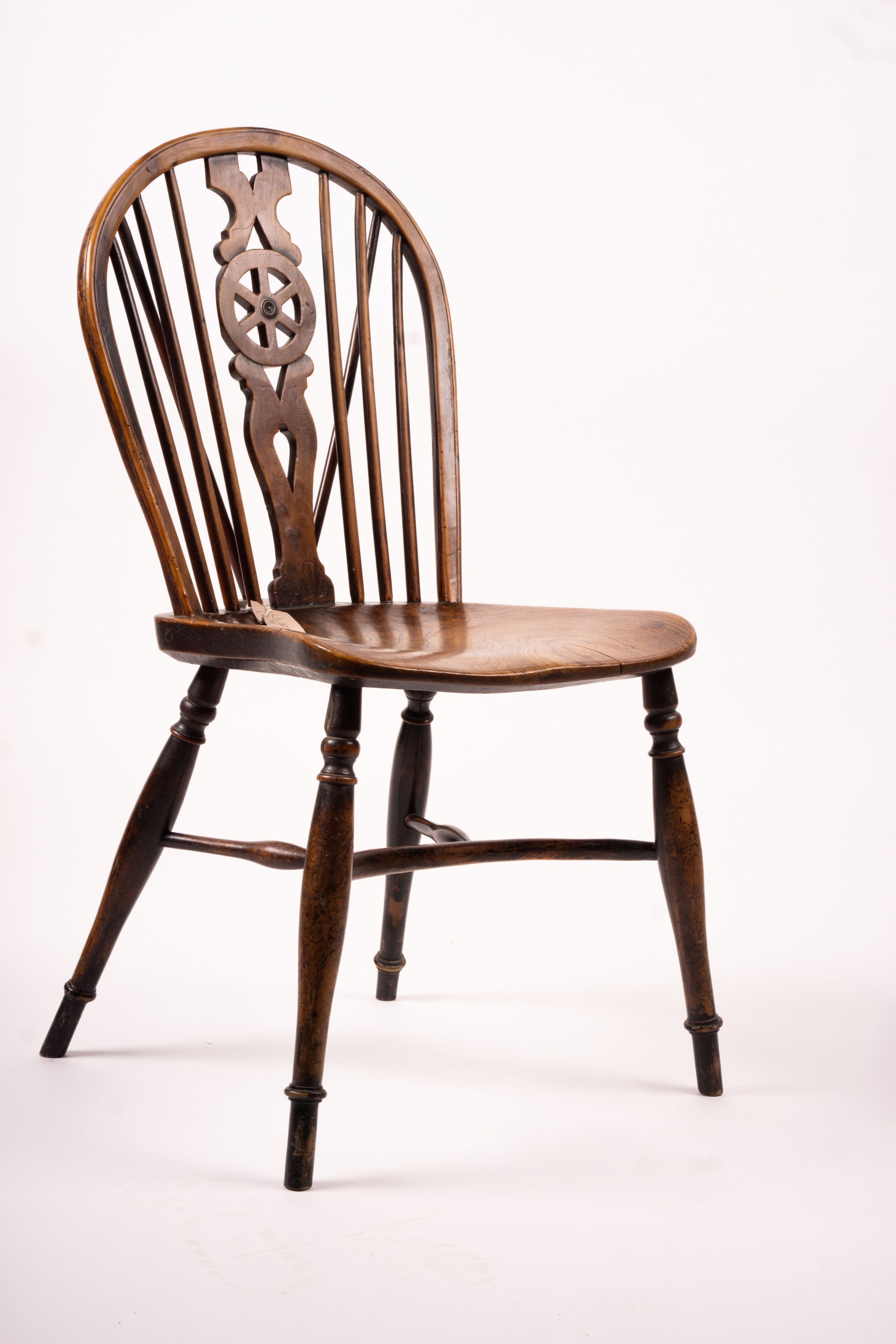 A mid 19th century ash and elm Derbyshire area Windsor elbow chair, together with a 19th century yew and elm Windsor wheel back chair with crinoline stretcher